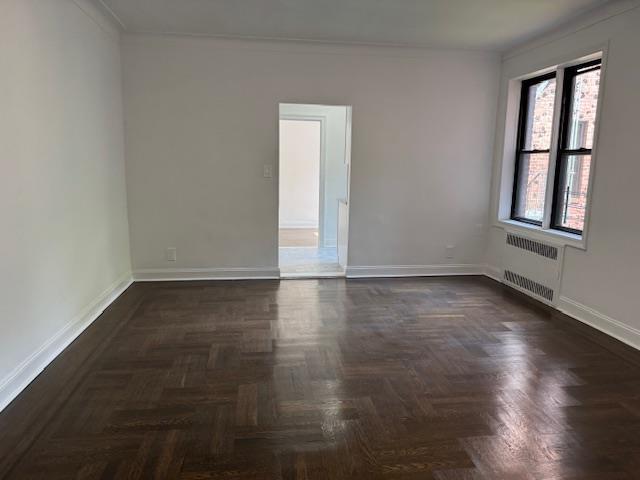 2515 Glenwood Rd Unit 2E, New York City, NY 11210 - unfurnished room featuring radiator heating unit, baseboards, and crown molding