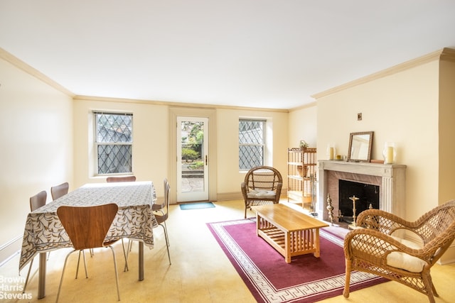 living area with a high end fireplace, ornamental molding, and a healthy amount of sunlight