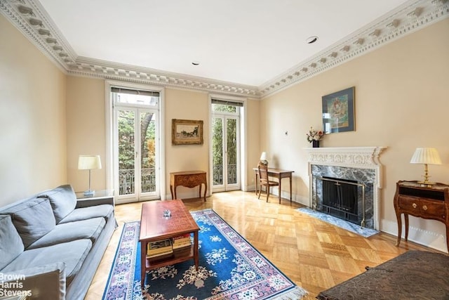 living room featuring a premium fireplace, baseboards, and ornamental molding