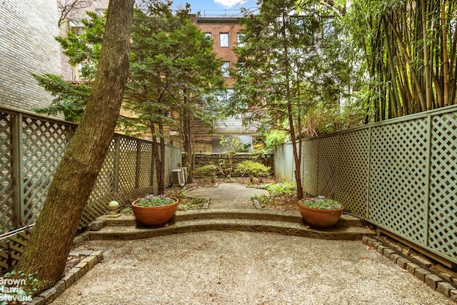 view of yard with a patio area, central air condition unit, and a fenced backyard