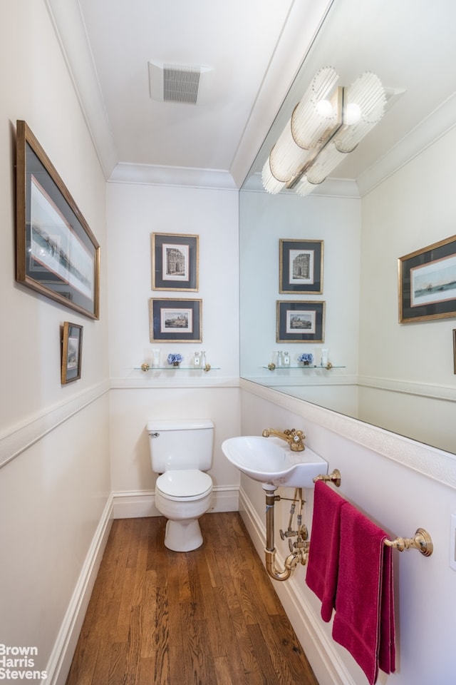 bathroom with visible vents, ornamental molding, toilet, and wood finished floors