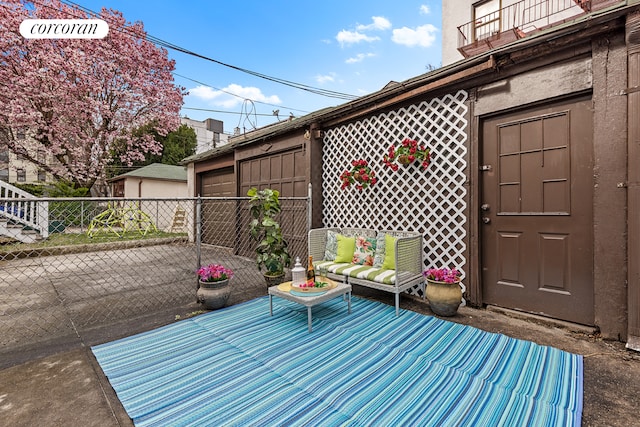 view of patio with fence and a balcony