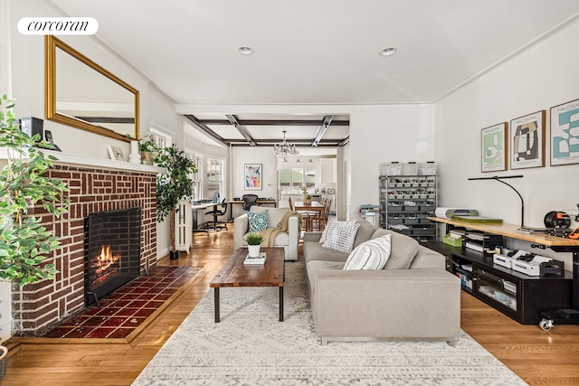 living room featuring an inviting chandelier, wood finished floors, a fireplace, recessed lighting, and coffered ceiling