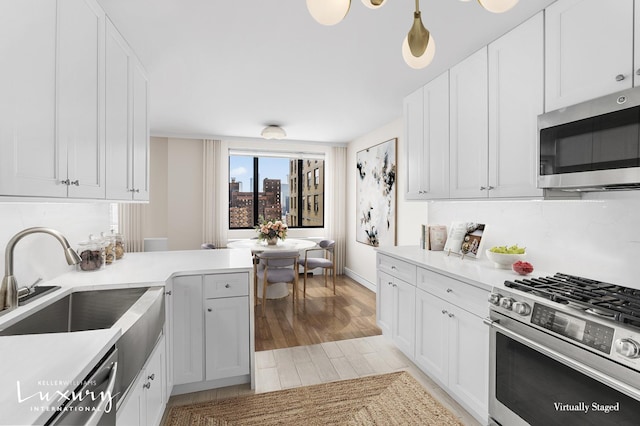 30 W 61st St Unit 24C, New York City, NY 10023 - kitchen with white cabinets, a sink, light wood-style floors, light countertops, and stainless steel appliances