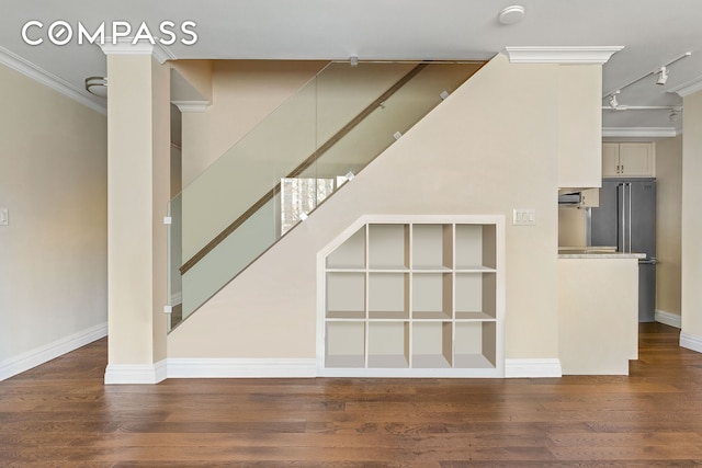 551 Main St Unit 208, New York City, NY 10044 - unfurnished living room with stairs, ornamental molding, wood finished floors, rail lighting, and baseboards