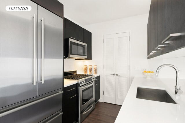 321 W 110th St Unit 12B, New York City, NY 10026 - kitchen featuring appliances with stainless steel finishes, a sink, dark cabinets, and dark wood-style floors