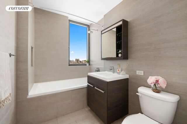321 W 110th St Unit 12B, New York City, NY 10026 - bathroom featuring toilet, vanity, tile walls, a relaxing tiled tub, and tile patterned flooring