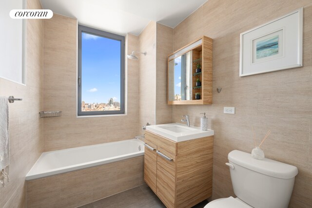 321 W 110th St Unit 12B, New York City, NY 10026 - bathroom with plenty of natural light, toilet, vanity, tiled shower / bath, and tile walls