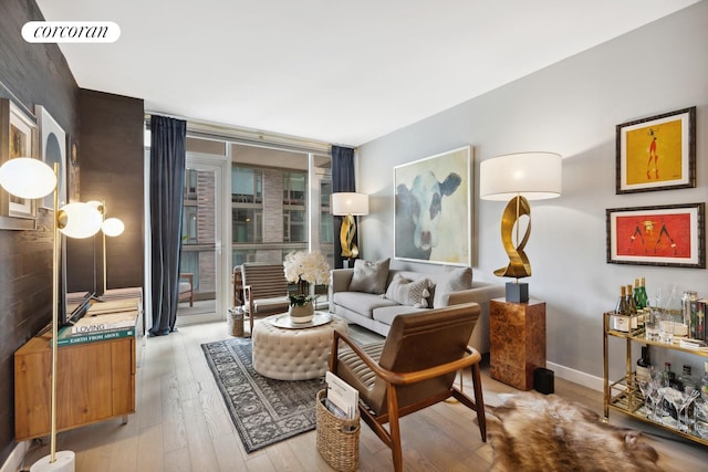 505 W 43rd St Unit 6K, New York City, NY 10036 - living room featuring wood finished floors, floor to ceiling windows, and baseboards