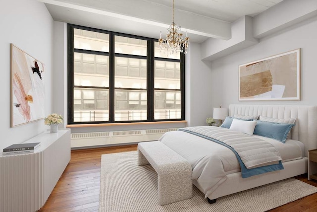 1 Main St Unit 7H, New York City, NY 11201 - bedroom featuring radiator heating unit, light wood finished floors, a notable chandelier, and beamed ceiling