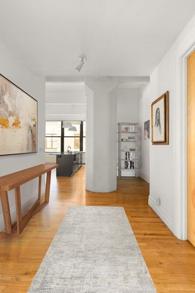 1 Main St Unit 7H, New York City, NY 11201 - hallway featuring light wood finished floors, baseboards, and a sink