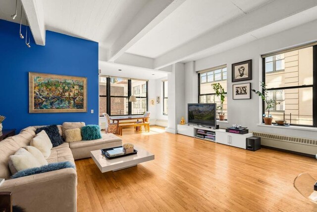 1 Main St Unit 7H, New York City, NY 11201 - living area with beam ceiling, baseboards, radiator, and hardwood / wood-style floors
