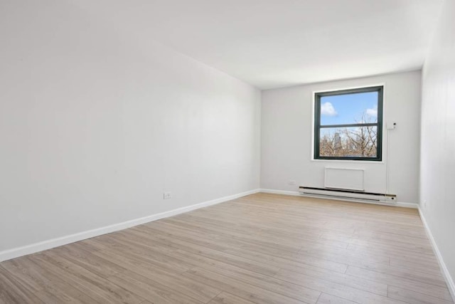 379 W St Unit 2B, New York City, NY 10014 - empty room featuring baseboard heating, light wood-style flooring, and baseboards
