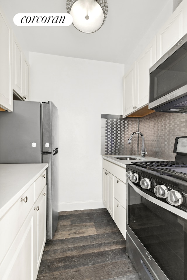 330 E 80th St Unit 3K, New York City, NY 10075 - kitchen with appliances with stainless steel finishes, a sink, decorative backsplash, dark wood finished floors, and light countertops