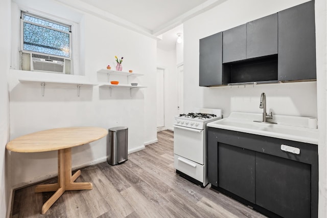 kitchen featuring white range with gas cooktop, light wood-style flooring, open shelves, cooling unit, and gray cabinets