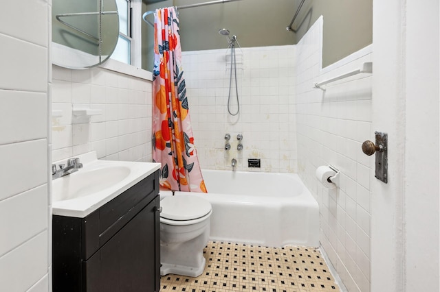 bathroom with tile walls, shower / bath combination with curtain, toilet, vanity, and tile patterned floors