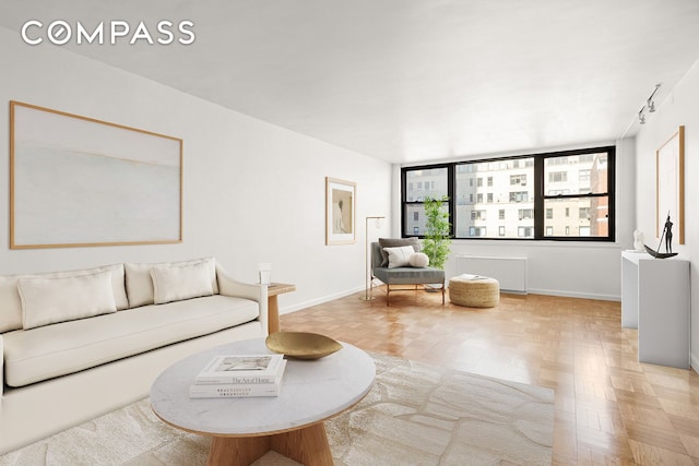 living area with baseboards and radiator