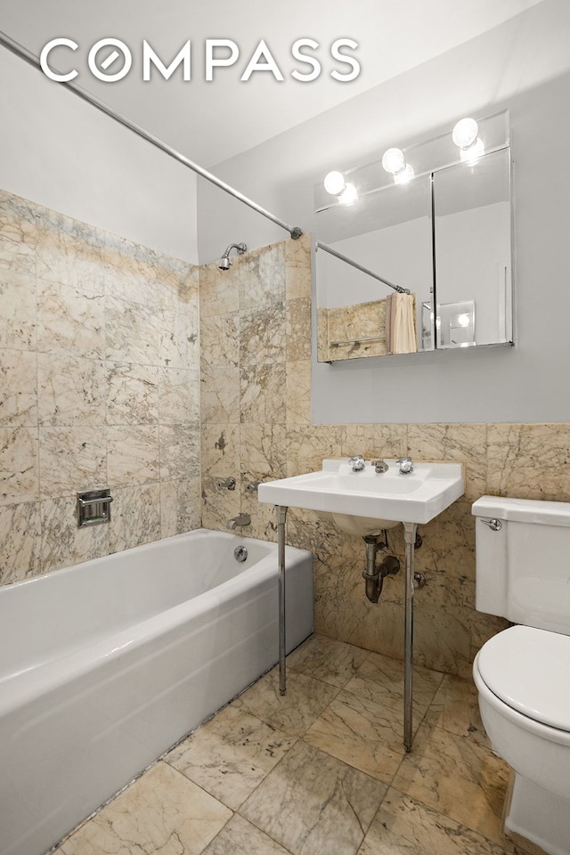full bathroom featuring tile walls, shower / tub combo, toilet, and marble finish floors