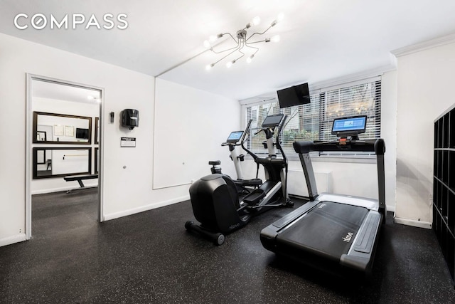 workout area featuring baseboards and a chandelier