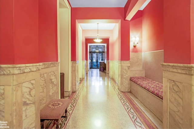 hall with wainscoting and tile walls