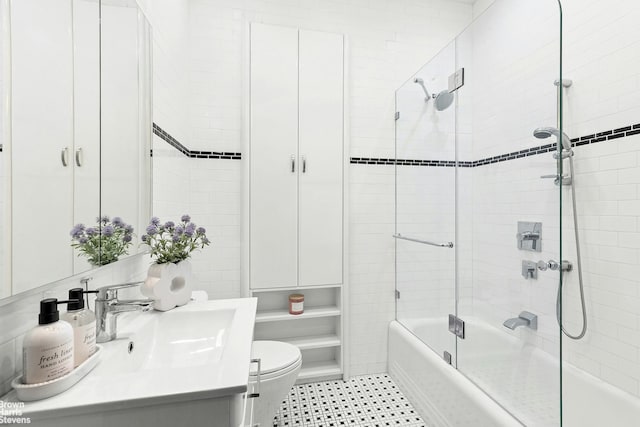 full bathroom featuring vanity, enclosed tub / shower combo, and toilet