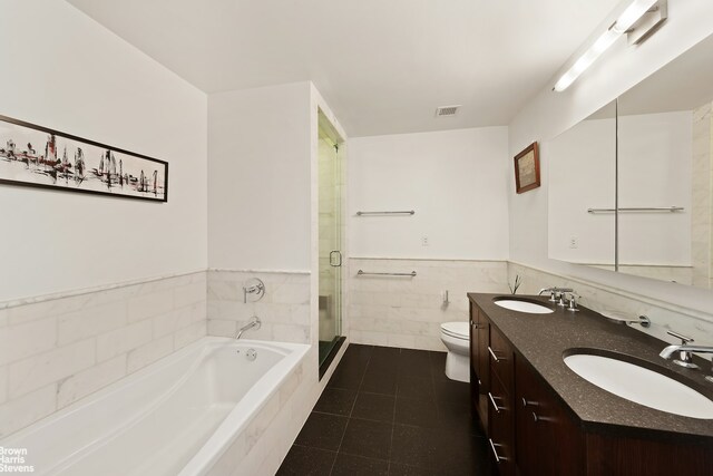 454 W 54th St Unit 7A, New York City, NY 10019 - bathroom with toilet, double vanity, a garden tub, tile patterned flooring, and wainscoting