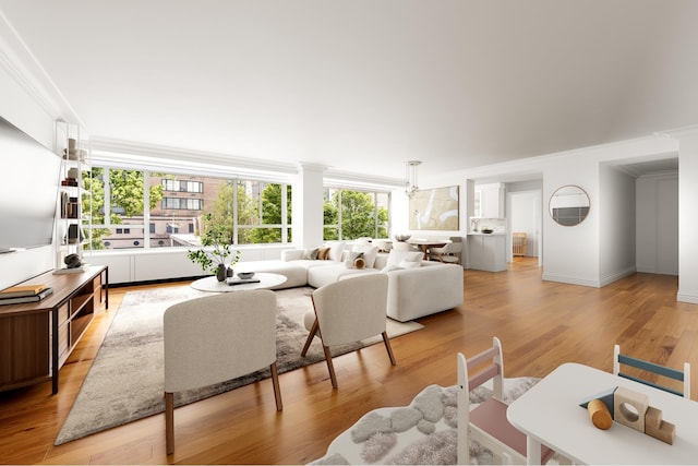living area with crown molding and light wood-style flooring