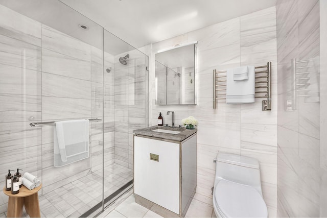 full bath with a shower stall, tile walls, a towel warming rack, toilet, and vanity