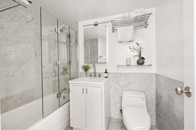 200 E 66th St Unit A301, New York City, NY 10065 - full bath with toilet, tile walls, combined bath / shower with glass door, a wainscoted wall, and vanity
