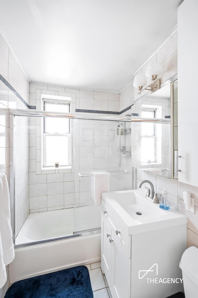 153 Bennett Ave Unit 3G, New York City, NY 10040 - bathroom with vanity, toilet, shower / bath combination with glass door, tile walls, and tile patterned flooring