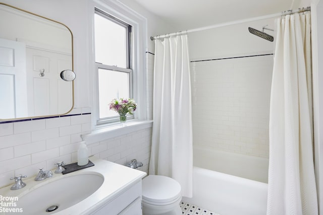 163 E 81st St Unit 6C, New York City, NY 10028 - bathroom featuring vanity, tile walls, shower / bath combo with shower curtain, and toilet