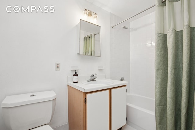 bathroom featuring toilet, shower / bath combo with shower curtain, and vanity