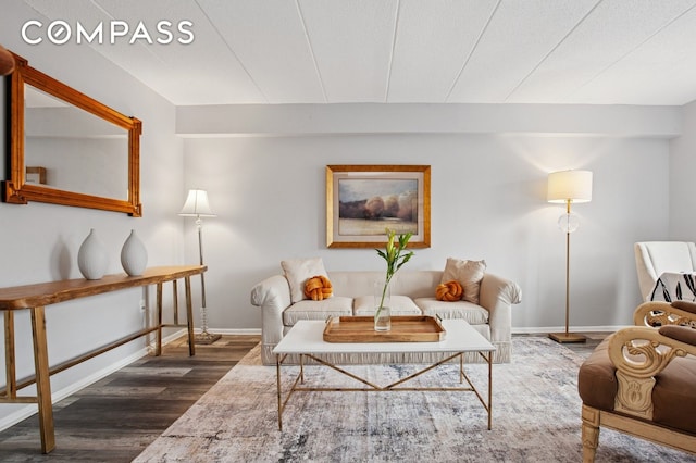 living room with dark wood-type flooring and baseboards