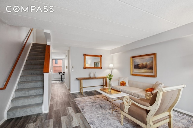 living area featuring stairway, wood finished floors, and baseboards