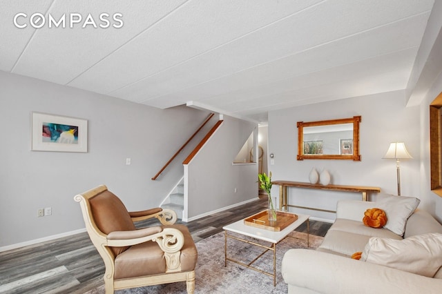 living area featuring wood finished floors, stairway, and baseboards