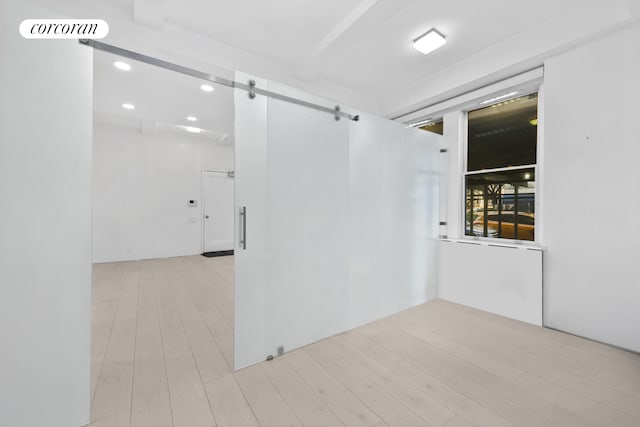 67 Park Ave Unit 1A, New York City, NY 10016 - empty room featuring a barn door, recessed lighting, and wood finished floors