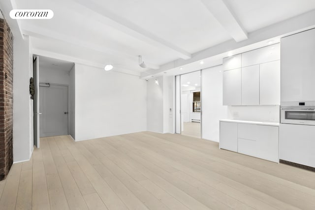 67 Park Ave Unit 1A, New York City, NY 10016 - unfurnished living room featuring beam ceiling, light wood finished floors, and recessed lighting