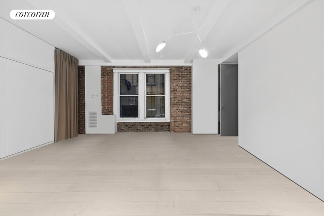 67 Park Ave Unit 1A, New York City, NY 10016 - empty room featuring brick wall and beamed ceiling