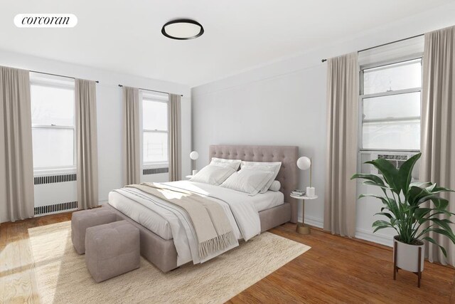 bedroom featuring radiator heating unit and wood finished floors