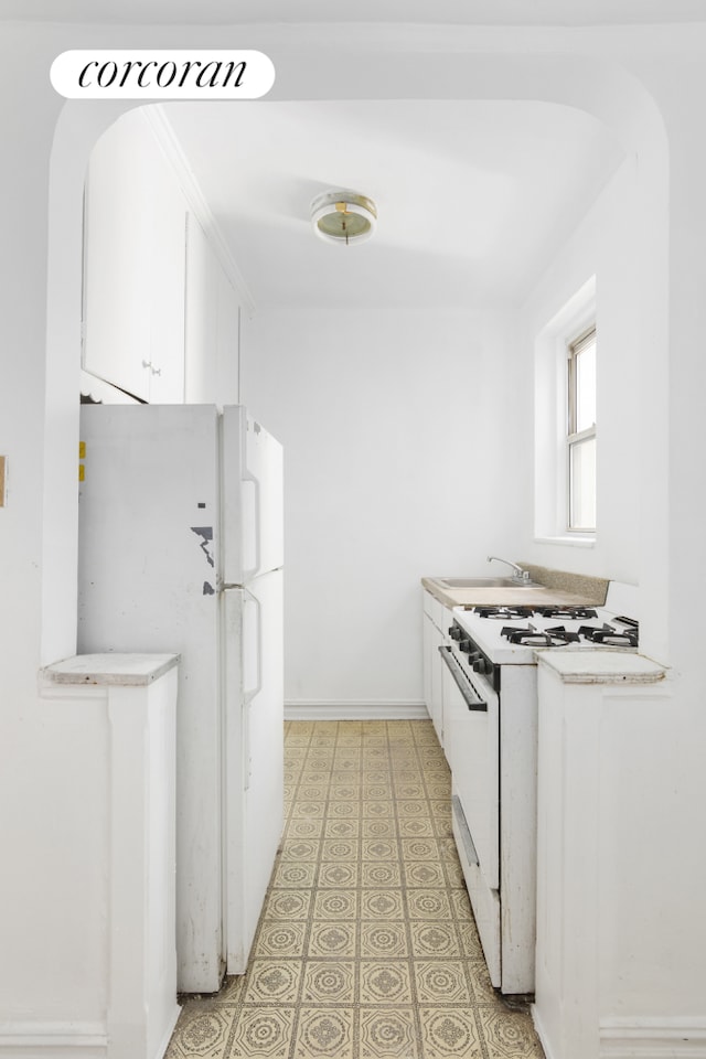 414 Albemarle Rd Unit 1D, New York City, NY 11218 - kitchen with white appliances, light flooring, white cabinets, light countertops, and arched walkways