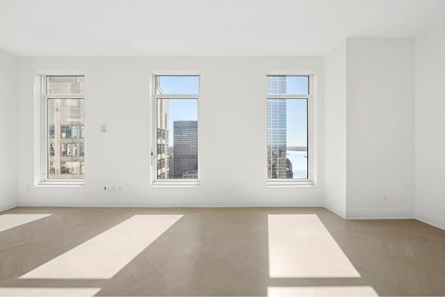 unfurnished room with a healthy amount of sunlight and baseboards