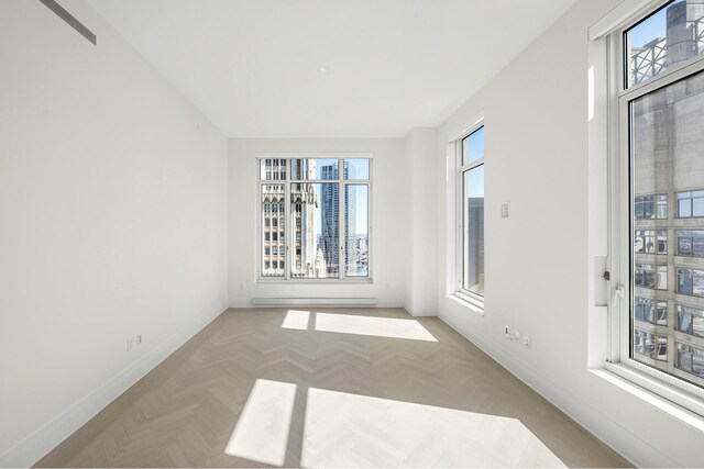 empty room featuring baseboards and baseboard heating