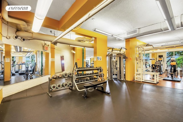 gym with a textured ceiling and visible vents