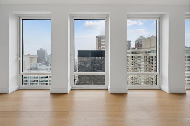 15 W 61st St Unit 27C, New York City, NY 10023 - empty room with a view of city, hardwood / wood-style flooring, and plenty of natural light