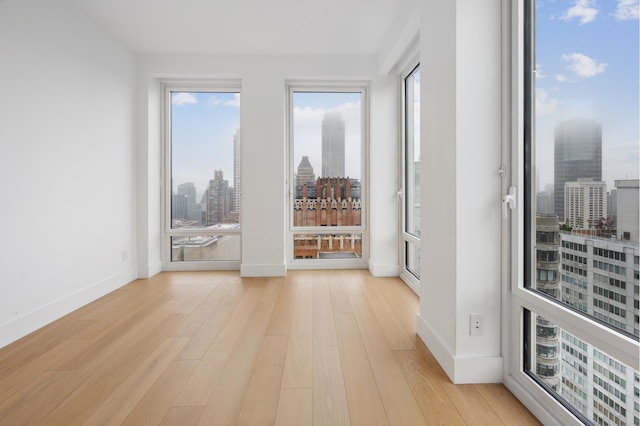 15 W 61st St Unit 27C, New York City, NY 10023 - spare room featuring a view of skyline and light wood finished floors