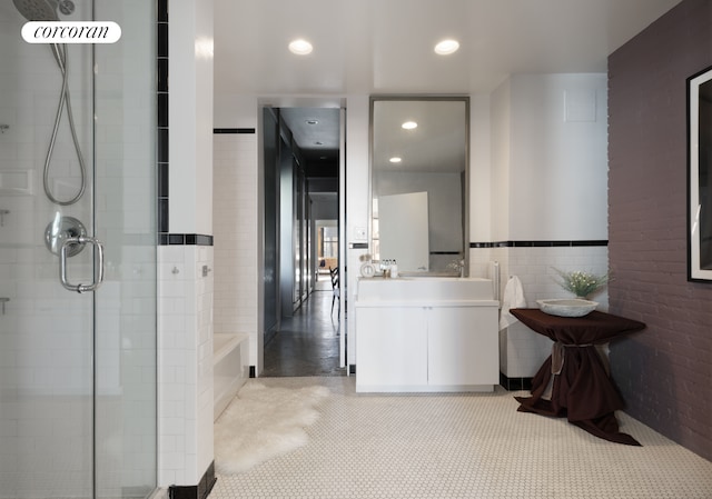 525 W 22nd St Phd, Phd, New York City, NY 10011 - full bathroom with a stall shower, recessed lighting, vanity, a bath, and tile walls