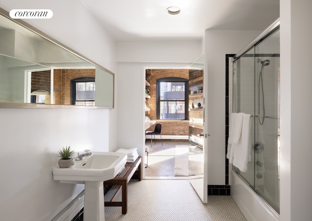 full bathroom with enclosed tub / shower combo, brick wall, and visible vents