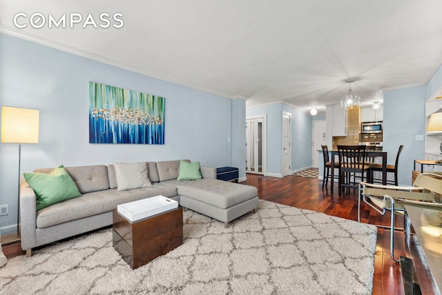 living room with baseboards, ornamental molding, and wood-type flooring