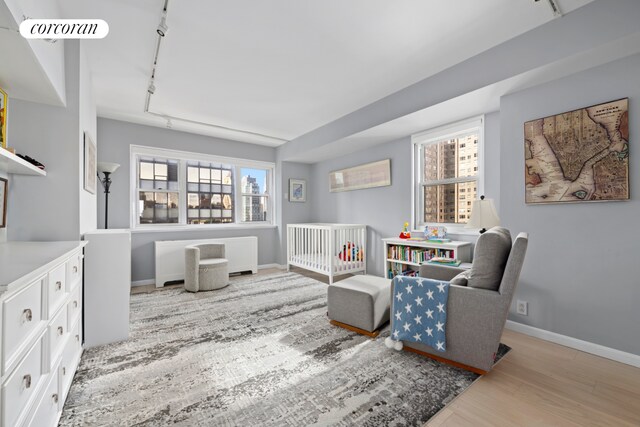 345 E 56th St Unit 21F, New York City, NY 10022 - sitting room with wood finished floors, baseboards, and rail lighting