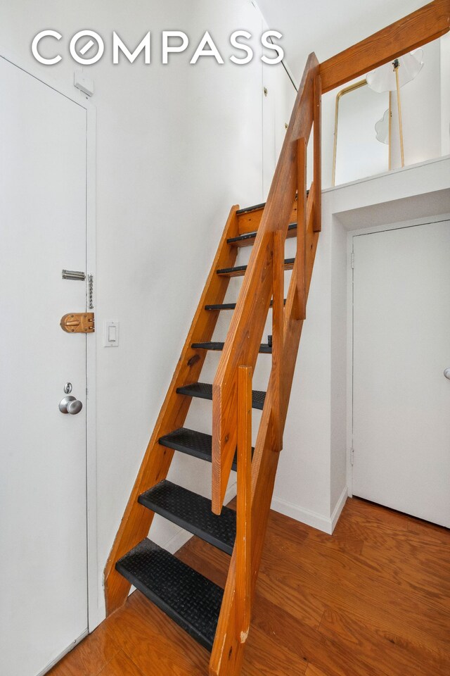 stairs with wood finished floors and baseboards